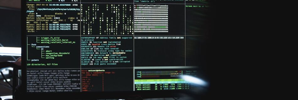 Close-up of a computer monitor displaying cyber security data and code, indicative of system hacking or programming.